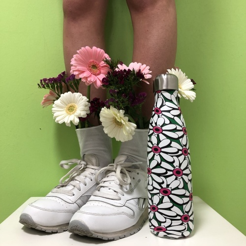 Borraccia pattern Flower vicino alle gambe di una ragazza con i fiori nelle calze bianche