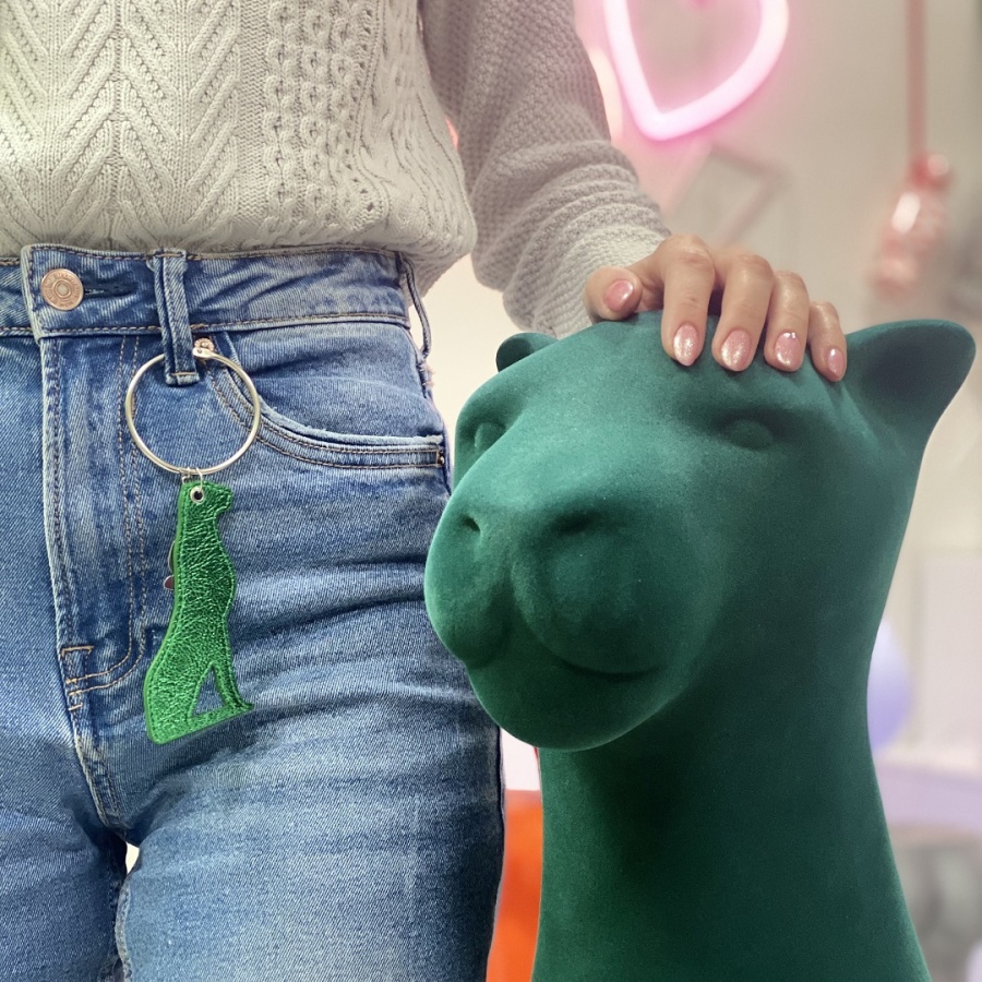Charm pantera Kira verde attaccato al jeans di una modella di fianco alla pantera Kira verde floccata
